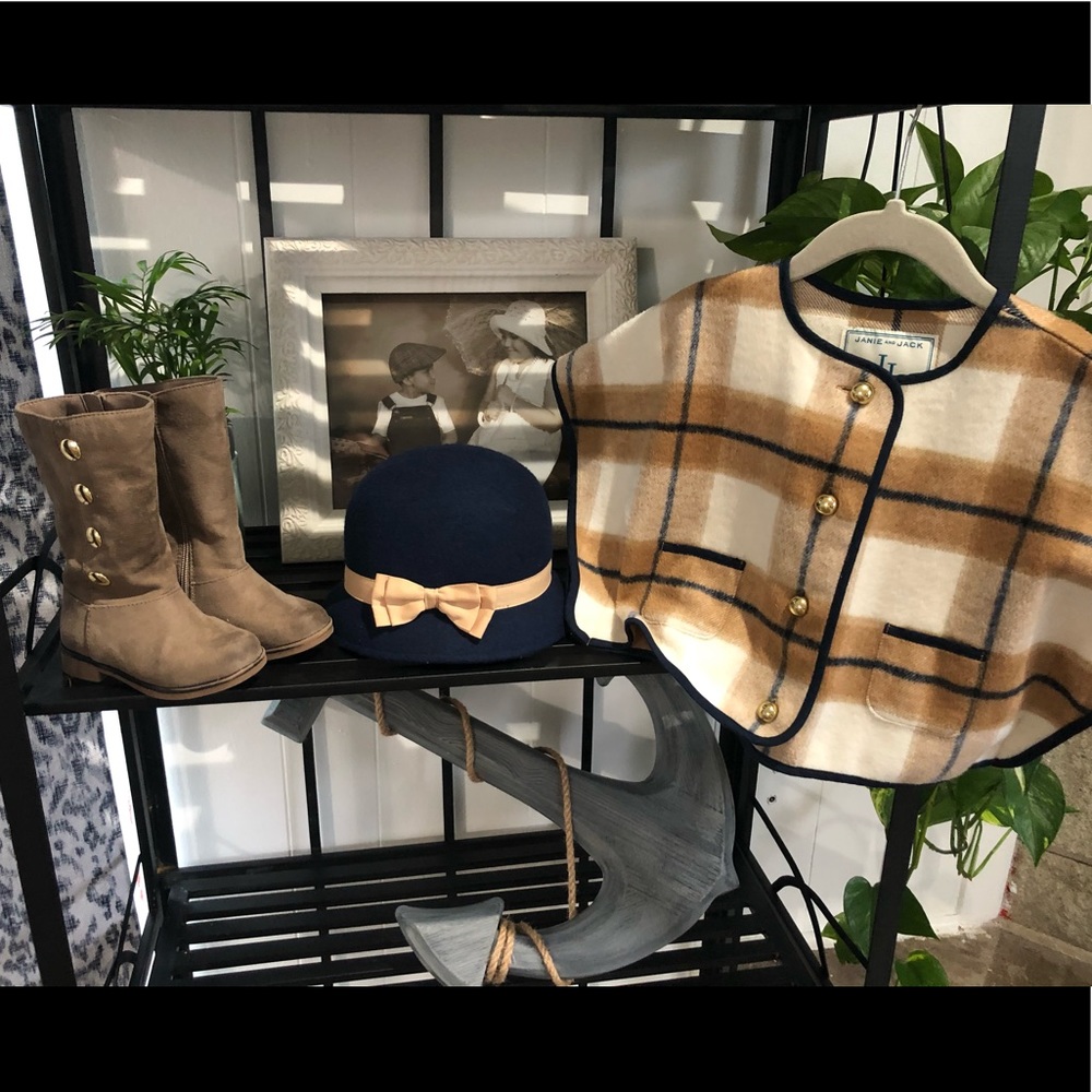 Poncho/cape, hat, and riding boots.